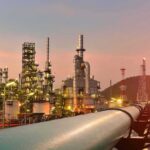 Oil Profits Are Surging—Now Comes The Tax Fight Oil refinery with pipelines at sunset