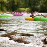 People floating on colorful inner tubes in a river