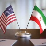 UN Referral Slams Tehran – Now What? United States and Iran desk flags on a stand