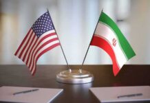 UN Referral Slams Tehran – Now What? United States and Iran desk flags on a stand