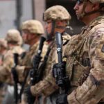 One Deadly Encounter, Missing Evidence, Growing Questions Soldiers in camouflage gear stand in formation holding rifles