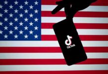 Pop Star’s White House Fight Hits A Twist Smartphone with TikTok logo held against a US flag backdrop