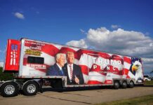 Semi trailer with large political campaign wrap beside a road