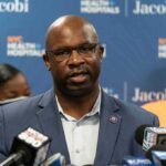 The Outbreak That’s Testing America’s Food System Man in suit speaking at a press conference