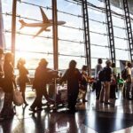 Unacceptable Acts? Ten Russians Expelled Passengers queue inside an airport terminal at sunset