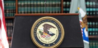Department of Justice podium with seal in front of bookshelves