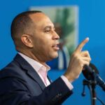 Racist Rhetoric Rocks House Leadership Man speaking at a microphone with raised finger