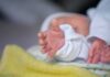 Newborn hand reaching out on a blanket