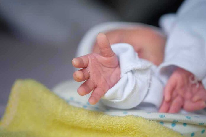 Newborn hand reaching out on a blanket