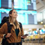 Death Sentence Showdown: Ex-PM Plans Return traveler with backpack checking flight information boards