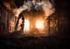 Mixed Barrage Torches Homes, Hospitals Strained Street with burning buildings and heavy smoke at night