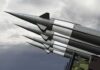 Missiles mounted on a launcher against a cloudy sky