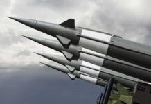 Missiles mounted on a launcher against a cloudy sky