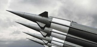 Missiles mounted on a launcher against a cloudy sky