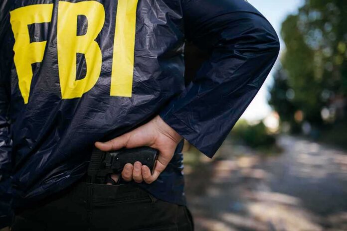 shutterstock_624106589 FBI agent in jacket drawing a handgun