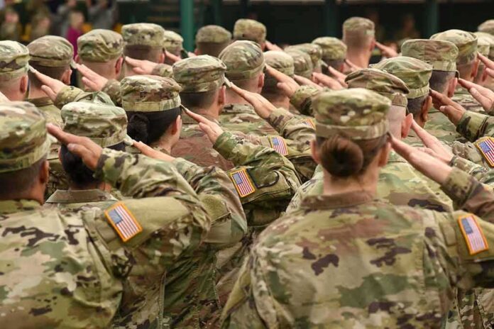 shutterstock_716498566 Soldiers in camouflage uniforms salute in formation