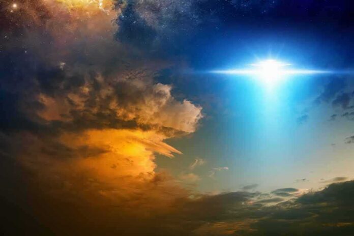 shutterstock_757721443-1 Bright blue light beam over dramatic clouds at dusk