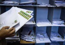 Hands sorting envelopes in a mailroom cubby
