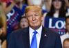 Constitution Showdown: Can Trump Pardon Trump? Donald Trump at a rally wearing a dark suit and blue tie