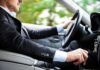 Driver in a suit operating a car