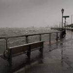 stormy waterfront promenade with benches and choppy water