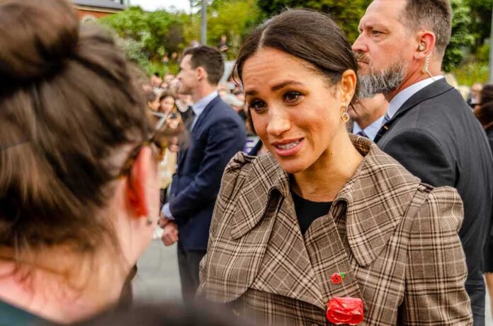 shutterstock_1216284850 Meghan, Duchess of Sussex greets a person in a crowd outdoors