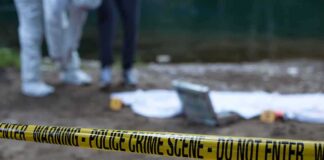 Police crime scene with yellow tape and forensic team