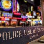 Police barrier with city nightlife in the background