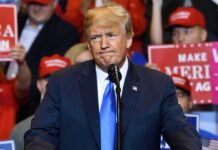 Donald Trump speaking at a rally podium