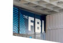 Congressman in Crosshairs – Why Him? FBI sign on building facade behind metal fence