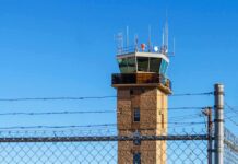 Runway Overrun Mystery: Wind Warning Missing Airport control tower behind chain-link and barbed-wire fence