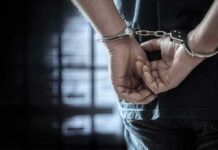 Hate Crime Charge After Street Spat person in handcuffs with hands behind back