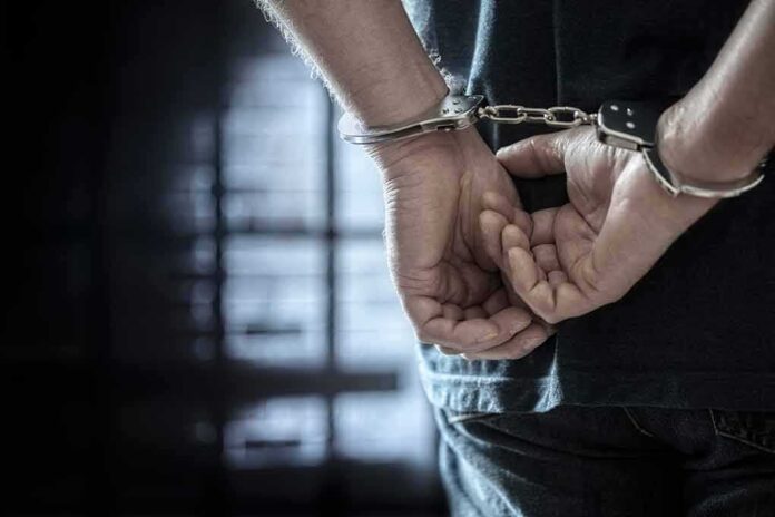 person in handcuffs with hands behind back