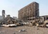 Burned-out cars amid a gutted high-rise building