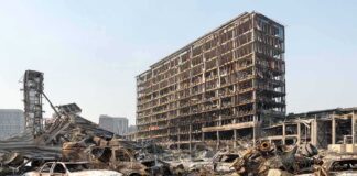 Burned-out cars amid a gutted high-rise building