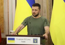 U.S. Test For Moscow – Will Shots Stop? Man at a podium with Ukrainian flags