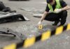 Forensic investigator marking evidence at crash scene