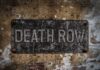Rusty metal sign on worn concrete wall