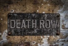 Words Become Death Sentence Rusty metal sign on worn concrete wall