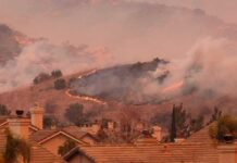 Red-Flag Inferno – Homes Torched, Power Cut Wildfire burns on hillside near suburban homes